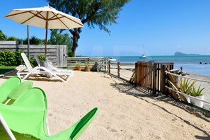 A beachside lounge with lounge chairs, a wooden fence, and a view of the ocean. - Beachfront MEERENA, 2 bedroom cottage with Jacuzzi in Calodyne (Calodyne)