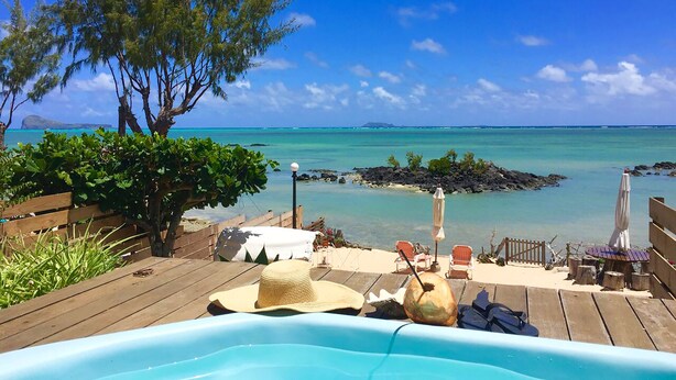 A wooden deck with a pool, lounge chairs, and a view of the ocean. - Beachfront MEERENA, 2 bedroom cottage with Jacuzzi in Calodyne (Calodyne)