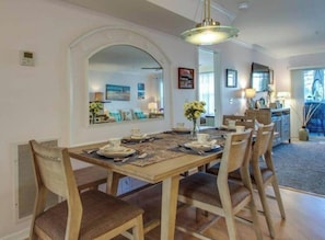 Comedor con una mesa de madera dispuesta para cuatro personas, rodeada de sillas.