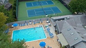 A residential area with a swimming pool, tennis courts, and lounge chairs. - Rehoboth 1st floor, End Unit Condo w/Pools & 5 Minute Bike Ride to Beach (Rehoboth Beach)