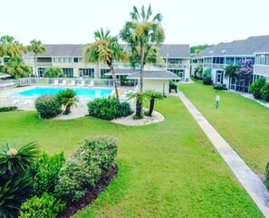 Relax by the resort's central pool surrounded by lush gardens and palm trees.