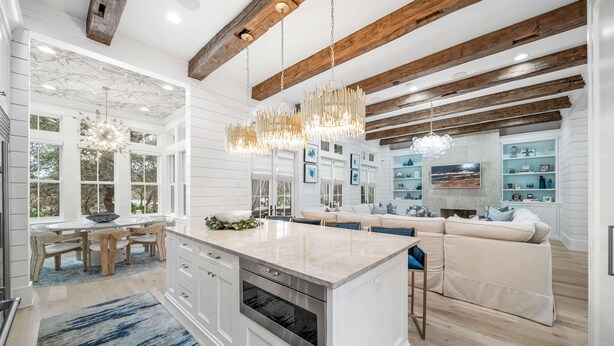 A spacious kitchen with a large island, wooden beams, and pendant lighting. - Amenity Loaded Designer Home on Western Lake with Pool, Elevator, Bikes, LSV (Santa Rosa Beach)