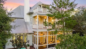 A two-story house with a balcony, large windows, and a swimming pool. - Amenity Loaded Designer Home on Western Lake with Pool, Elevator, Bikes, LSV (Santa Rosa Beach)