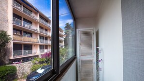 A balcony with a view of a multi-story building, a window with blinds, and a radiator. - JUNGLE LUXURY FLAT WITH BALCONY AND PRIVATE PARKING IN CASSIS CENTER+WIFI (Cassis)