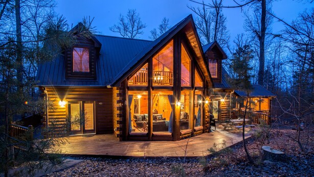 A log cabin with a large deck, multiple windows, and a balcony. - Kozy Bear 3 King BRs | Hot Tub | Pool Table (Sevierville)