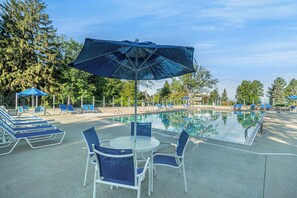 A poolside area with lounge chairs, a table, and umbrellas. - 🏖️Sleepy Hollow Beach Resort, Shore 46 – Family Fun on Lake Michigan! (South Haven)