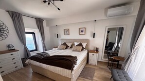 A bedroom with a bed, bedside tables, a dresser, a chair, and a mirror. - Amber's Place, Cosy House With Pool and sea Views (Dubrovnik)