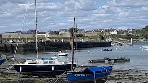 A harbor with boats, a stone wall, and houses in the background. - Villa du Pêcheur, Gâvres Peninsula (Gâvres)