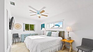 Quarto com cama, ventilador de teto, janela, luminária e cadeira.
