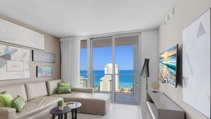 A modern living room with a large window offering a view of the ocean and cityscape. - Front Ocean View: Amazing Pools (Hollywood)