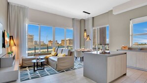 Una sala de estar moderna con un sofá, una zona de comedor y una isla de cocina.