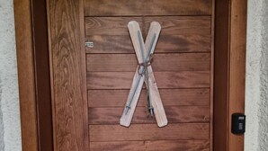 Eine Holztür mit rustikalem Design, einem Metallgriff und einem dekorativen, kreuzförmigen Gegenstand.