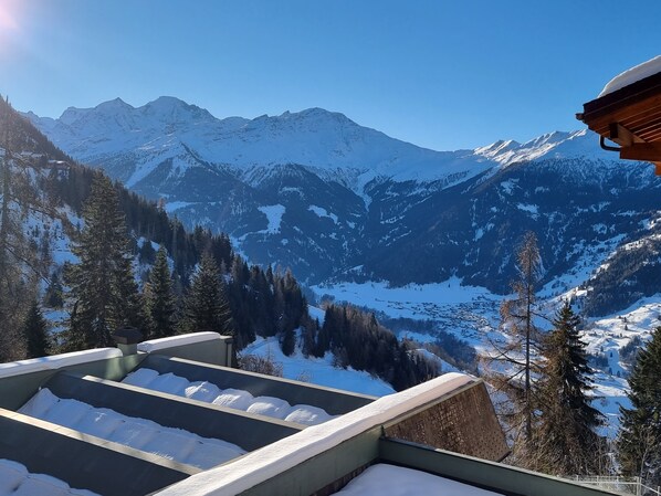 Un paysage de montagne enneigé, sous un ciel dégagé.