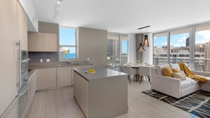 A modern apartment with a kitchen, dining area, and living room. It features large windows, a balcony, and a city view. - Wrap Around Balcony|Awesome View|Amazing Pools (Hollywood)