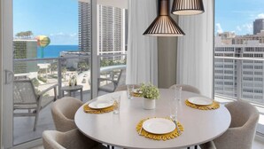 A dining area with a round table set for four, a potted plant, and two pendant lights. - Wrap Around Balcony|Awesome View|Amazing Pools (Hollywood)