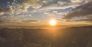 A landscape with a sun setting behind a tree line. - Crestone Mountain Retreat House: Quiet in Nature (Saguache County)