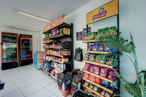 A grocery store interior with shelves stocked with snacks, beverages, and other groceries.