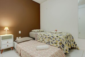 Een slaapkamer met twee bedden, een nachtkastje en een lamp.