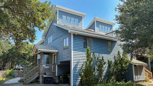 Une maison à deux étages avec un porche abrité et un petit garage attenant.