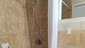 Un baño con bañera, ducha y lavamanos.