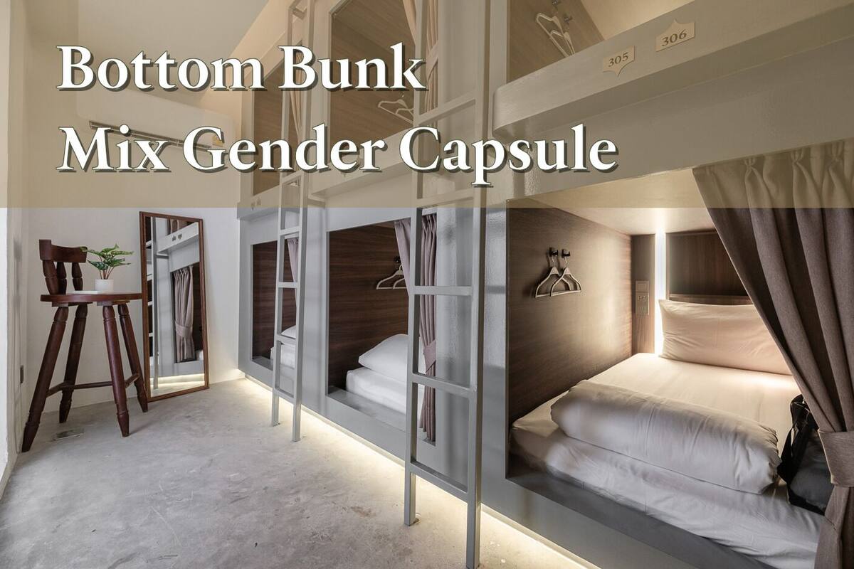 A room with bunk beds, a desk, and a chair.