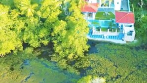 An aerial view of a property surrounded by dense greenery, featuring a large building with a red roof and a visible swimming pool. - Charming Villa With Pool, Near Beach, Sri Lanka (Kahandamodara)