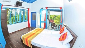 A room with a bed, a balcony with a table and chairs, and a view of greenery. - Charming Villa With Pool, Near Beach, Sri Lanka (Kahandamodara)