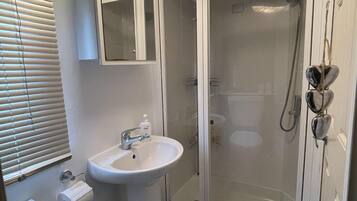 Bathroom features a sink, mirror, and shower enclosure.