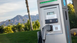 Una estación de carga con pantalla digital, puerto de conexión y un código QR para la gestión del software.