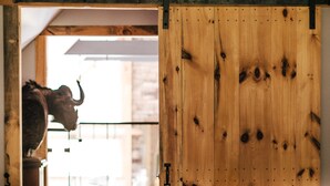 Une pièce dotée d’une porte coulissante en bois, d’un canapé blanc et d’une statue de taureau.
