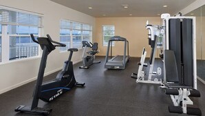 A gym with treadmills, an elliptical, and weight machines.