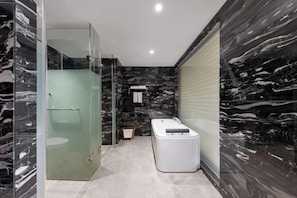 A modern bathroom with a glass-enclosed shower, a white bathtub, and marble walls. - Jiangyong Hotel (Jiangyong)