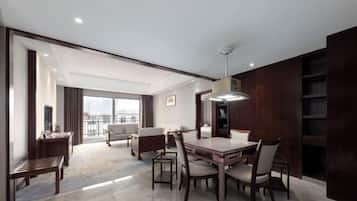 Una habitación de hotel moderna con comedor, un ventanal y vistas a la ciudad.