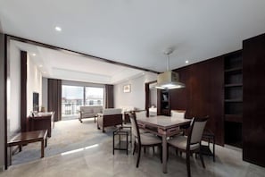 A modern hotel room with a dining area, a large window, and a view of the city. - Jiangyong Hotel (Jiangyong)