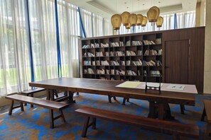 A library with bookshelves, a long table, and benches. - Jiangyong Hotel (Jiangyong)