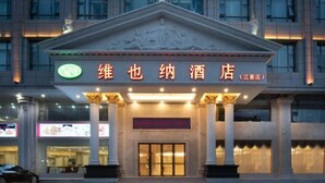 A hotel entrance with a sign in Chinese characters, a classical architectural style with columns, and a well-lit facade. - Vienna Hotel (Xinyi Jiaoyucheng River View) (Xinyi)