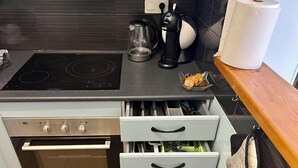 Una cocina con horno empotrado, cafetera y hervidor.