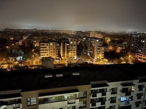 A nighttime cityscape with illuminated buildings and streets. - Amazing 2-Room Penthouse Cityview W13 (Bucharest)