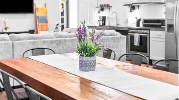 Una cocina moderna con una mesa de comedor de madera, sillas grises y una planta en maceta.