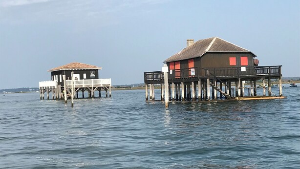 Two wooden structures with balconies over water, likely used for lodging or dining. - Bigazen - Family house sleeps 8 (Biganos)