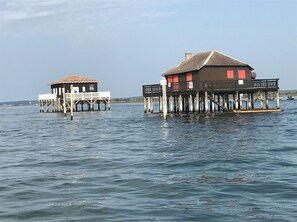 Two wooden structures with balconies over water, likely used for lodging or dining. - Bigazen - Family house sleeps 8 (Biganos)