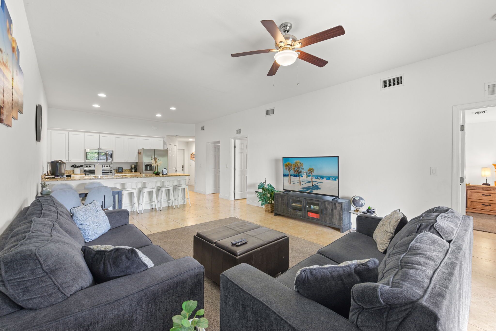 A modern living room with a grey sofa set, a coffee table, and a ceiling fan.