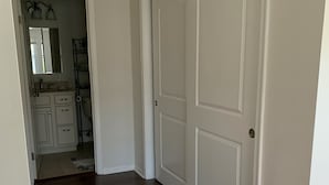 Un pasillo con piso de madera que conduce a una puerta cerrada.