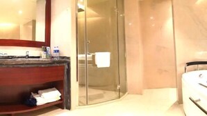 A modern bathroom with a glass-enclosed shower, a marble countertop, and a white bathtub. - Xiangrui Hotel (Changde)