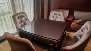 A conference room with a dark table and tufted leather chairs. - Xiangrui Hotel (Changde)