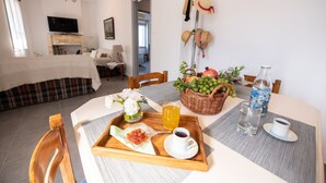 Bandeja de desayuno con tostadas, mermelada y té sobre una mesa de madera en una habitación de hotel.