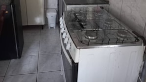A kitchen with a stove, sink, and cabinets.