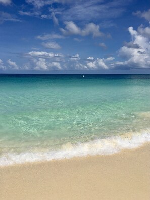Ein Strand mit klarem türkisblauem Wasser und sandigem Ufer.