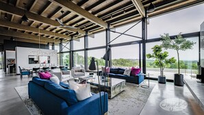 A spacious living area with a modern design, featuring a large sofa set, a coffee table, and a dining area. - 5bdrm 7bath modern oasis in Creemore! Pool! Hot Tub! Sauna! Podcast Media Rm! (Creemore)