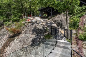 Stroll up the stone staircase surrounded by lush greenery and large rocks to a shaded pavilion.